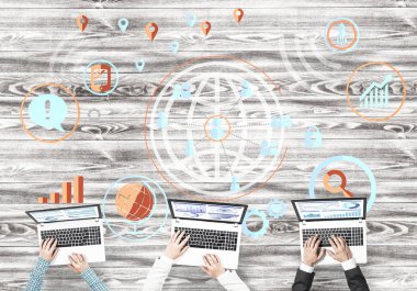 Bir grup ellerinde aygıtlarla üç insan