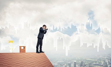 Çatıda duran ve dürbünle bakan bir iş adamı. Karıştırdı.