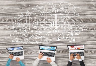 Bir grup ellerinde aygıtlarla üç insan