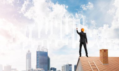 Mühendis adam evin çatısında ayakta 