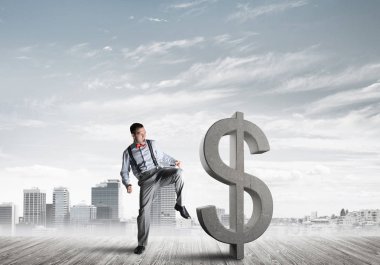 Gürültüyle çarpmak ile olacak genç öfkeli işadamı tekme modern cityscape karşı Doları sembol taş