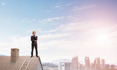 Çatının kenarında duran işadamı 