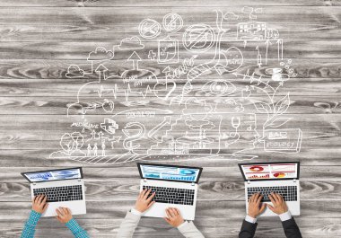 Bir grup ellerinde aygıtlarla üç insan