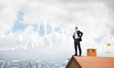 Evin çatısında duran genç işadamı 