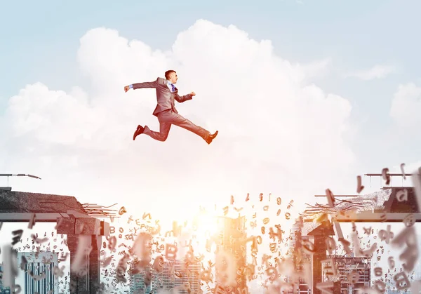 Businessman jumping over gap with flying letters in concrete bridge as symbol of overcoming challenges with cityscape on background, 3D rendering