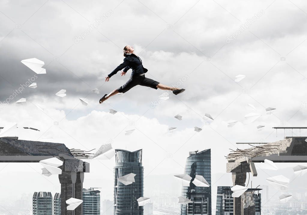 Business woman jumping over gap
