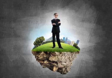 Yeşil yüzen ada üzerinde duran işadamı