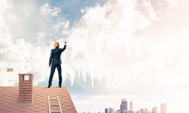 Mühendis adam evin çatısında ayakta 