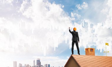 Mühendis adam evin çatısında ayakta 