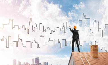 Mühendis adam evin çatısında ayakta 