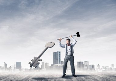 Kararlı işadamı çekiçle kırma taş anahtar şekil cityscape karşı 