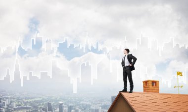 evin çatısında duran işadamı