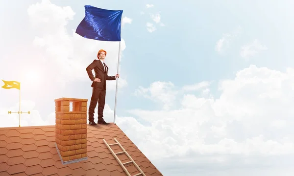 Businessman standing on house roof — Stock Photo, Image