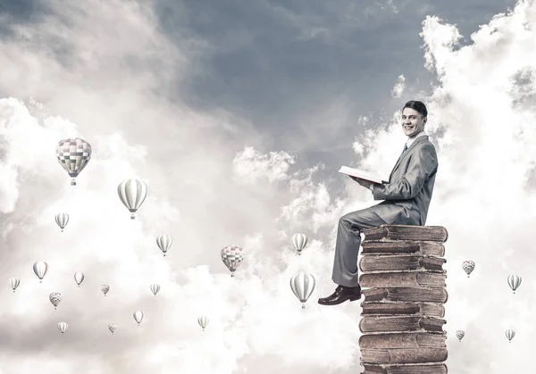 Joven Hombre Negocios Sentado Montón Libros Aerostatos Volando Aire — Foto de Stock