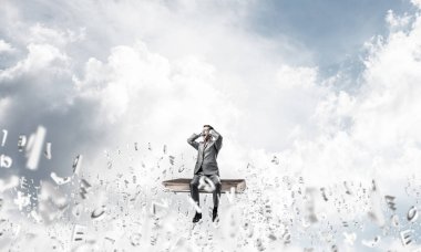 Kitap üzerinde oturan işadamı 