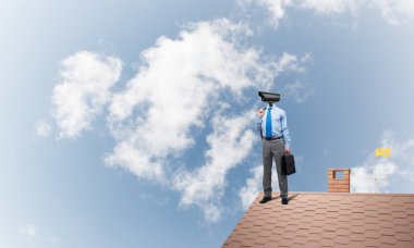 Meçhul işadamı ile kamera zoom yerine baş ayakta evin çatısında, ev güvenlik ve gizlilik koruma kavramı