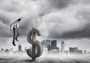 Öfkeli genç işadamı gürültüyle çarpmak ile dolar sembol modern cityscape karşı taş yumruk olacak