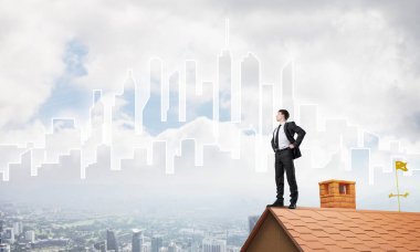 evin çatısında duran işadamı