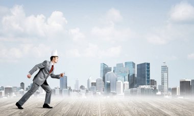 Acele ile cityscape arka planda çalışan beyaz kağıt taç giyen genç yakışıklı işadamı 