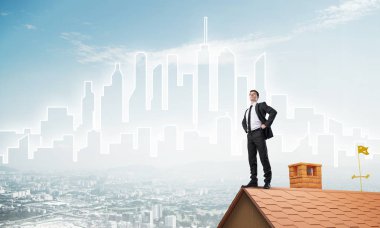 evin çatısında duran işadamı