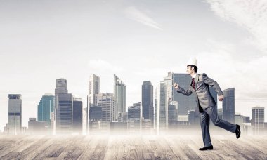 Acele ile cityscape arka planda çalışan beyaz kağıt taç giyen genç yakışıklı işadamı 