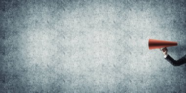 İşkadını beton arka planı kırmızı kağıt trompet tutan eli