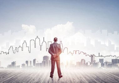 İşadamı arkasını dönüp modern iş merkezinin siluetine bakıyor.