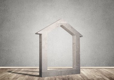 Ev taşı figürü, boş beton odadaki gayrimenkullerin sembolü.
