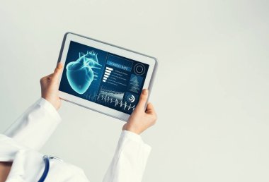 Doktorun ellerinde ilaç arayüzü ekranı olan tablet pc aygıtı