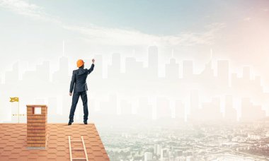 Mühendis adam evin çatısında ayakta 