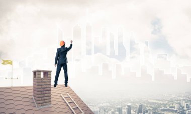 Mühendis adam evin çatısında ayakta 