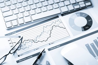 Klavye fareli iş yeri ve grafik ve diyagramlı kağıtlar