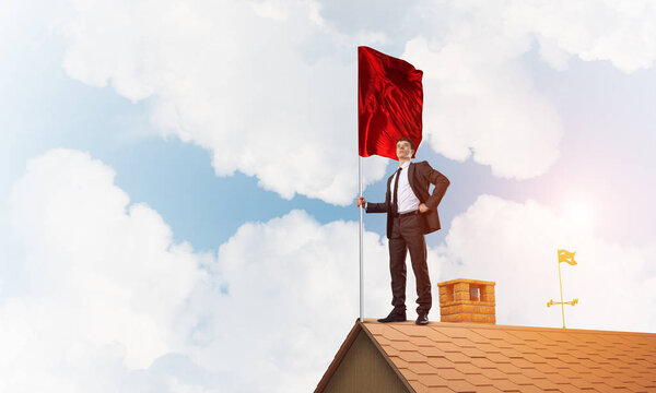 businessman standing on house roof