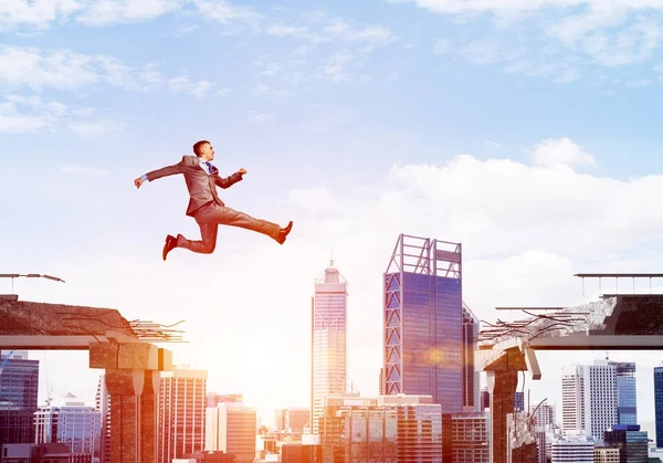 Бізнесмен стрибає через розрив — стокове фото
