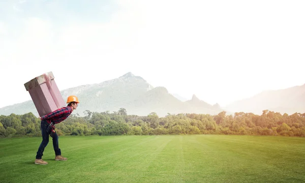 Man carrying on back large box — Stock Photo, Image