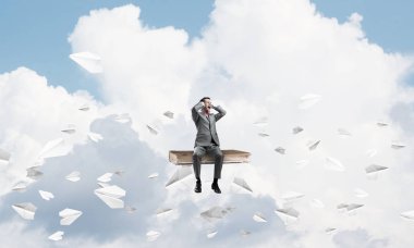 eski kitap üzerinde oturan işadamı