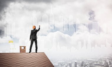 Mühendis adam evin çatısında ayakta 