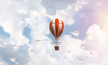 Renkli aerostat kağıt uçaklar arasında ve mavi bulutlu gökyüzü üzerinde uçan. 