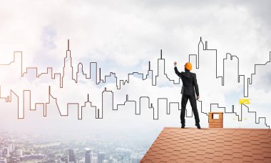 Mühendis adam evin çatısında ayakta 