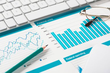 Klavye fareli iş yeri ve grafik ve diyagramlı kağıtlar