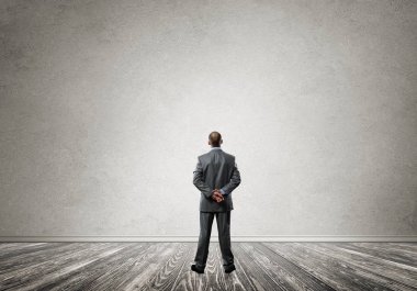 Boş beton odada kendine güvenen zarif iş adamının arka planı