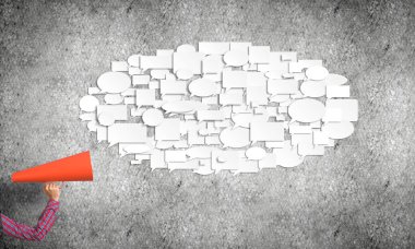 Beton arka planda kırmızı borazan tutan bir kadın eli