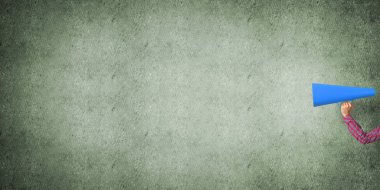 El kağıt trompet beton arka planda tutan kadın