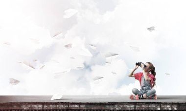 Dürbünle bakan, okul çağındaki sevimli kız çatıyı inşa ediyor.