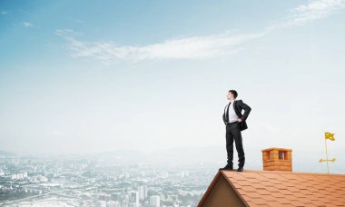 evin çatısında duran işadamı 