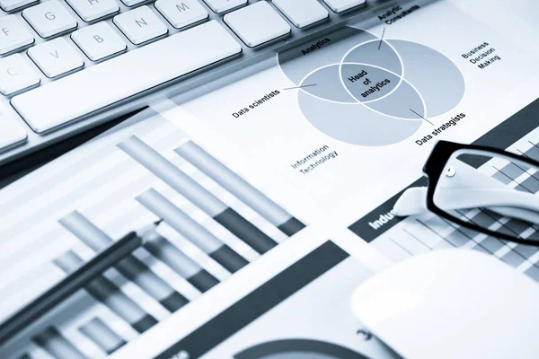 Business workplace with keyboard mouse and papers with graphs and diagrams