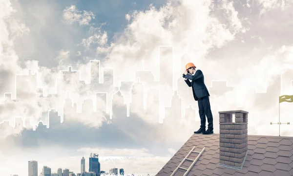 Uomo in piedi sul tetto e guardando in binocolo — Foto Stock