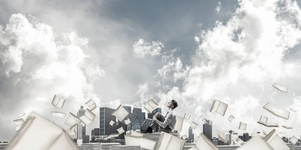 背景に空の Cloudly 本を飛行中の書類の山に座ってよそ見の実業家 ミクスト メディア — ストック写真