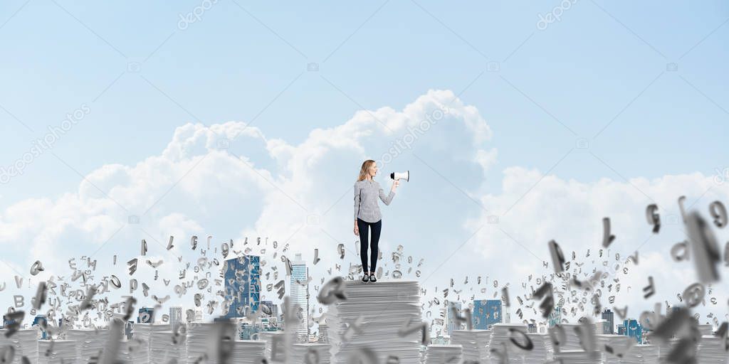 Woman in casual clothing standing among flying letters with speaker in hand and with skyscape on background. Mixed media.