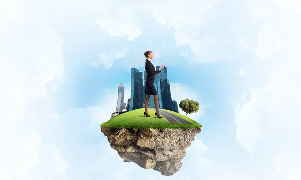 Businesswoman standing on green floating island — Stock Photo, Image